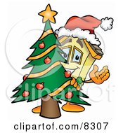 House Mascot Cartoon Character Waving And Standing By A Decorated Christmas Tree