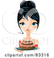 Black Haired Blue Eyed Woman Holding Out A Birthday Cake With Pink Frosting And Candles