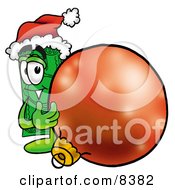 Dollar Bill Mascot Cartoon Character Wearing A Santa Hat Standing With A Christmas Bauble by Toons4Biz