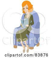 Relaxed Red Haired Caucasian Woman Wearing A Robe Sitting In A Chair And Reading A Book