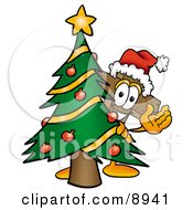 Wooden Cross Mascot Cartoon Character Waving And Standing By A Decorated Christmas Tree