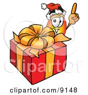 Flame Mascot Cartoon Character Standing By A Christmas Present