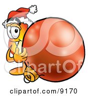 Clipart Picture Of A Flame Mascot Cartoon Character Wearing A Santa Hat Standing With A Christmas Bauble