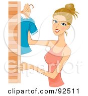 Dirty Blond Woman Hanging Clothes In A Closet