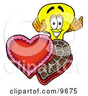 Light Bulb Mascot Cartoon Character With An Open Box Of Valentines Day Chocolate Candies